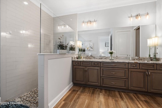 bathroom with hardwood / wood-style flooring, vanity, walk in shower, and ornamental molding