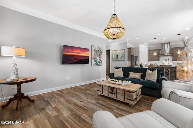 living room featuring dark wood-type flooring, a chandelier, and crown molding