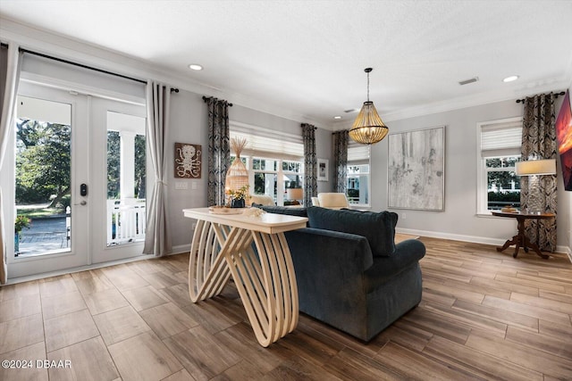 living room with ornamental molding, french doors, plenty of natural light, and wood-type flooring