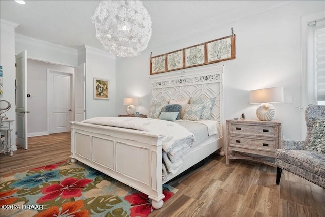 bedroom featuring light hardwood / wood-style flooring, a chandelier, and crown molding