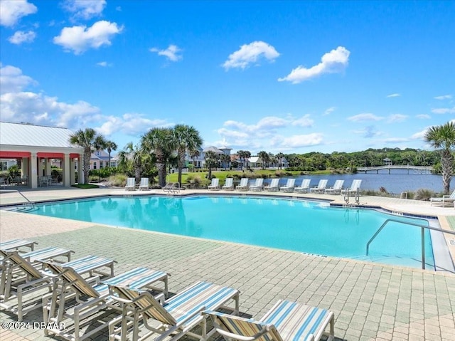 view of pool featuring a water view and a patio area