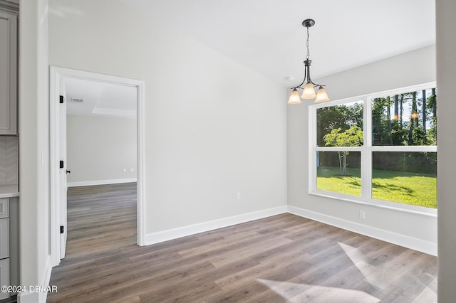 unfurnished room featuring hardwood / wood-style flooring and a chandelier