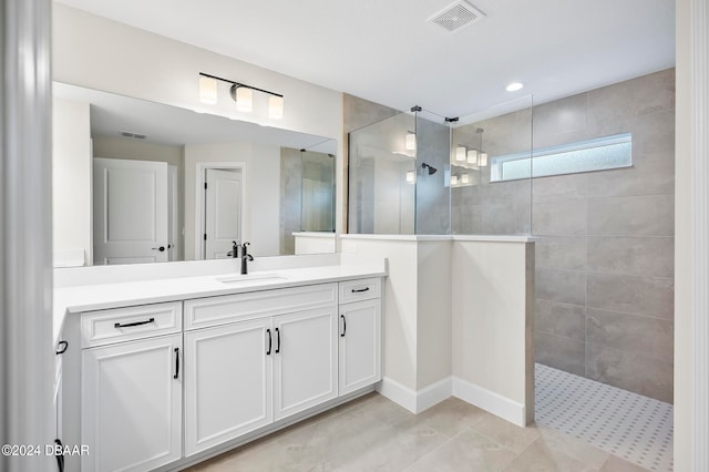 bathroom featuring vanity, tile patterned flooring, and a tile shower