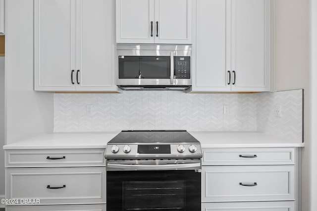 kitchen with stainless steel appliances, white cabinetry, and backsplash