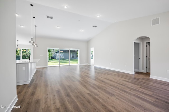 unfurnished living room with dark hardwood / wood-style flooring, high vaulted ceiling, and sink