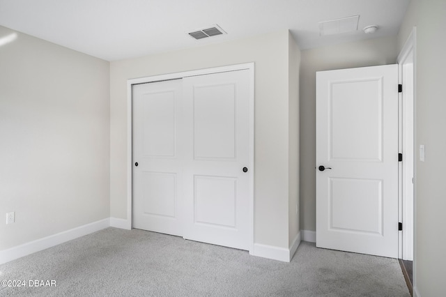 unfurnished bedroom featuring a closet and light carpet