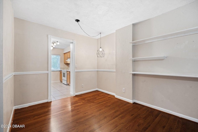 unfurnished dining area featuring light hardwood / wood-style floors and a textured ceiling