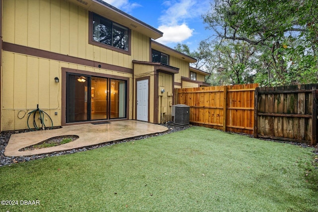 back of property featuring a lawn, a patio area, and central AC