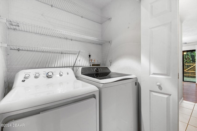 washroom featuring washer and clothes dryer and light tile patterned floors