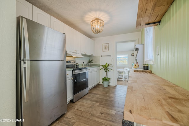 kitchen featuring tasteful backsplash, light hardwood / wood-style flooring, stainless steel appliances, and white cabinets