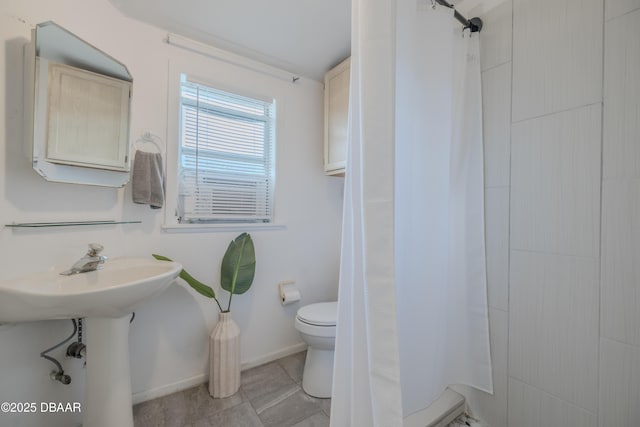 bathroom with sink, curtained shower, and toilet