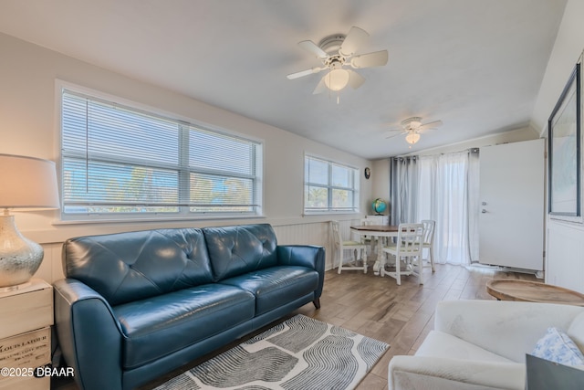 living room with ceiling fan and light hardwood / wood-style flooring