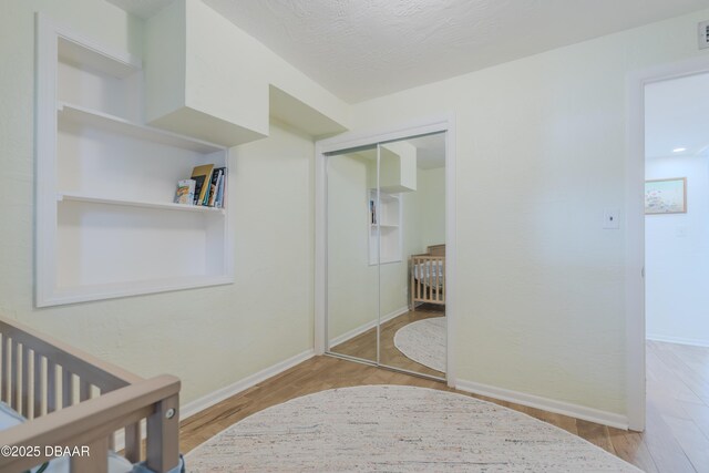 bedroom with light hardwood / wood-style flooring, a closet, and a textured ceiling