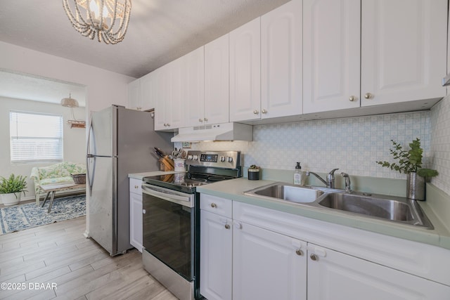 kitchen with sink, white cabinetry, stainless steel appliances, decorative backsplash, and light wood-type flooring