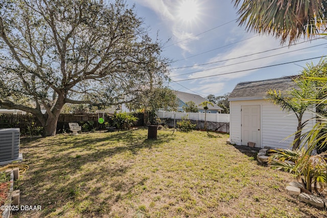 view of yard featuring central AC and a storage shed