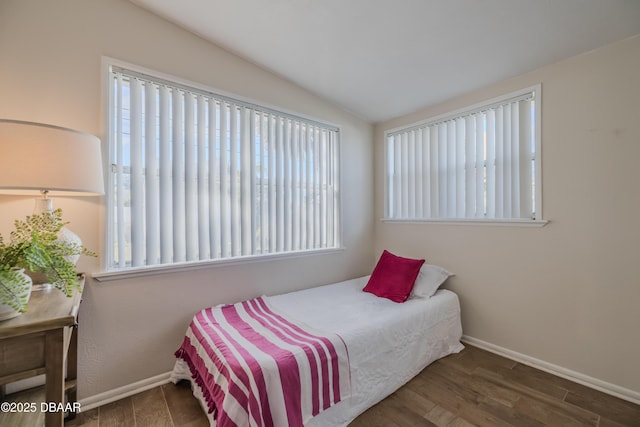 bedroom featuring lofted ceiling and dark hardwood / wood-style floors