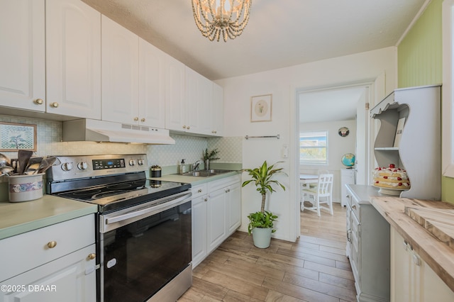 kitchen with electric stove, sink, white cabinetry, backsplash, and light wood-type flooring