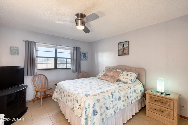 tiled bedroom featuring a textured ceiling and ceiling fan