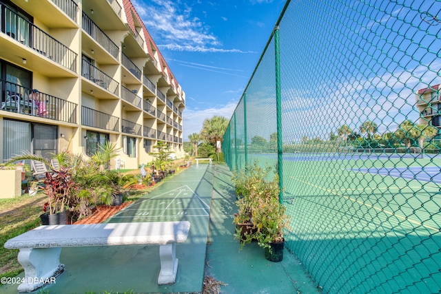 view of home's community with tennis court