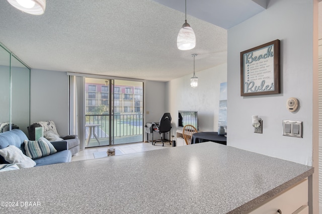 kitchen featuring a wall of windows, a textured ceiling, and decorative light fixtures