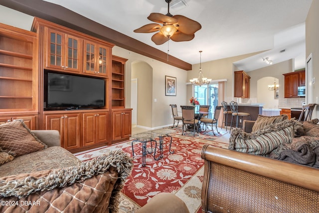 living room featuring built in shelves and ceiling fan with notable chandelier