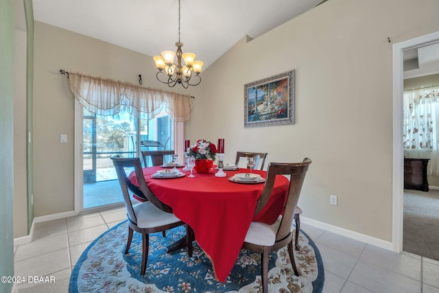 dining room with a chandelier, light tile patterned floors, and vaulted ceiling