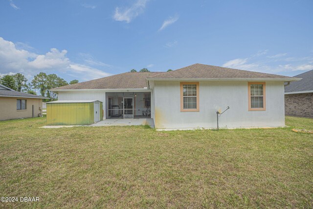 back of property with a patio, a lawn, and a sunroom