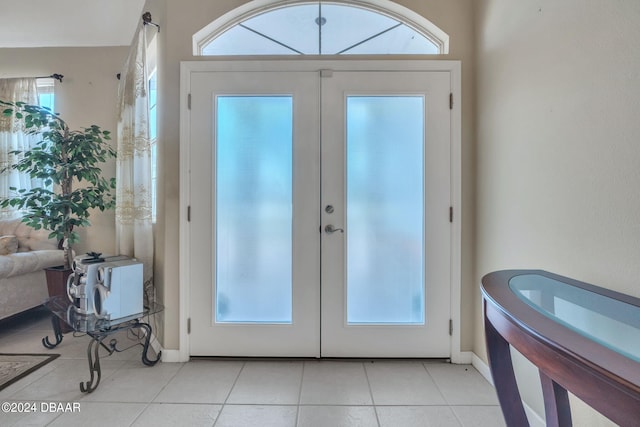 doorway to outside with a healthy amount of sunlight, light tile patterned floors, and french doors