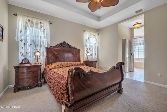 carpeted bedroom with ensuite bathroom and ceiling fan