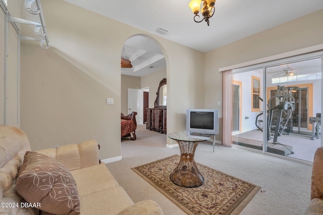 carpeted living room featuring a tray ceiling and ceiling fan