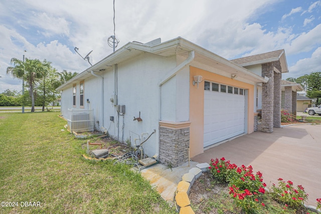 view of side of property with central AC unit, a garage, and a yard