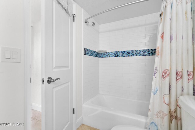 bathroom with tile patterned flooring and shower / bath combo