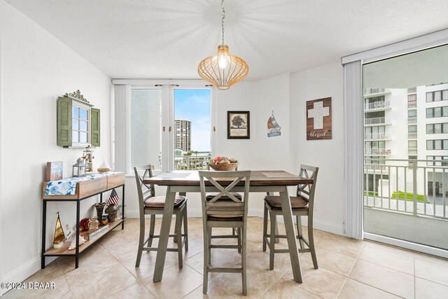 tiled dining room featuring a wall of windows and a textured ceiling