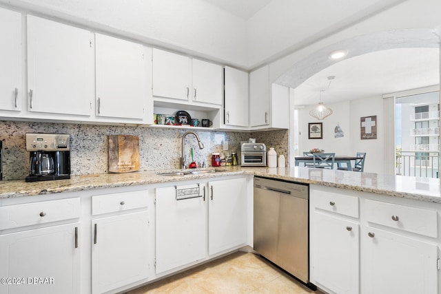 kitchen featuring stainless steel dishwasher, white cabinets, sink, and light stone counters