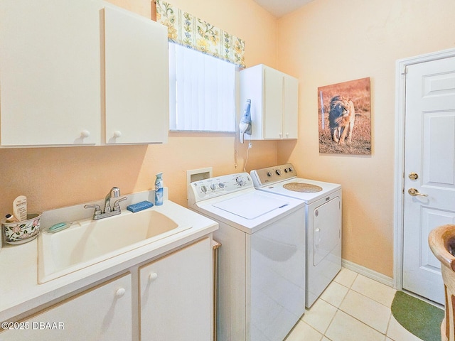 clothes washing area with independent washer and dryer, cabinets, sink, and light tile patterned floors