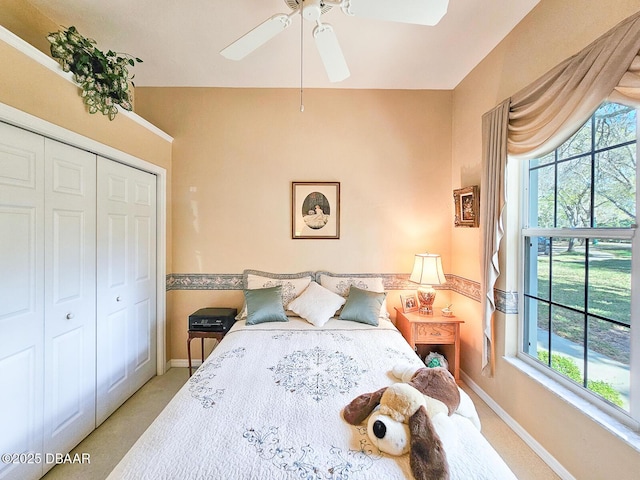 bedroom featuring light colored carpet, a closet, and ceiling fan