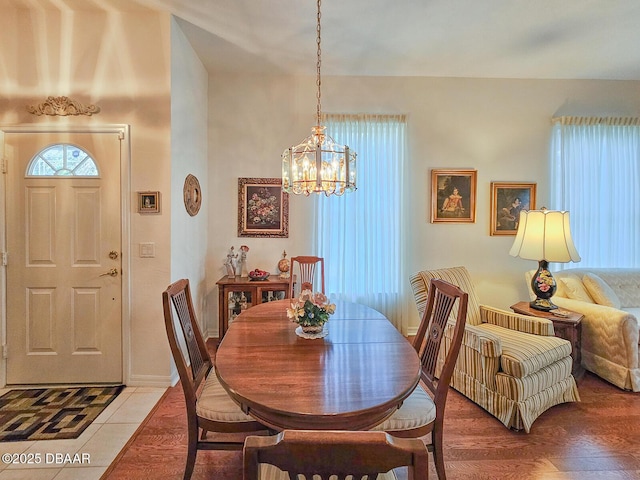 dining space with wood-type flooring and a chandelier