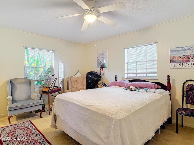 bedroom with light colored carpet, a textured ceiling, and ceiling fan