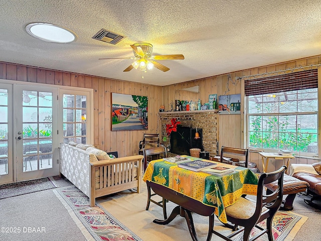 bedroom with visible vents, a textured ceiling, a brick fireplace, and access to exterior