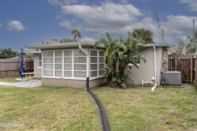 exterior space featuring cooling unit and a lawn