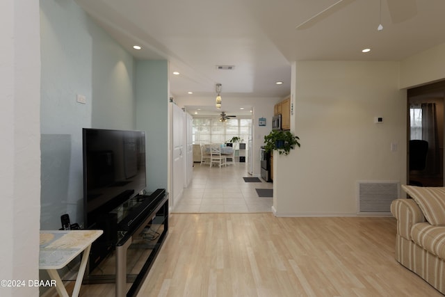 living room with light hardwood / wood-style flooring and ceiling fan