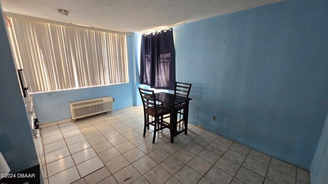 dining area with a wall unit AC and light tile patterned flooring