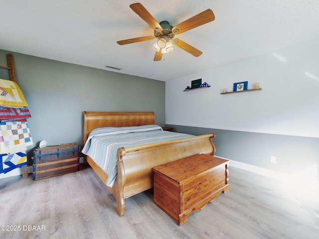 bedroom featuring ceiling fan, a textured ceiling, and light hardwood / wood-style flooring