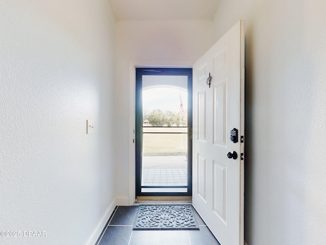 doorway with dark tile patterned flooring