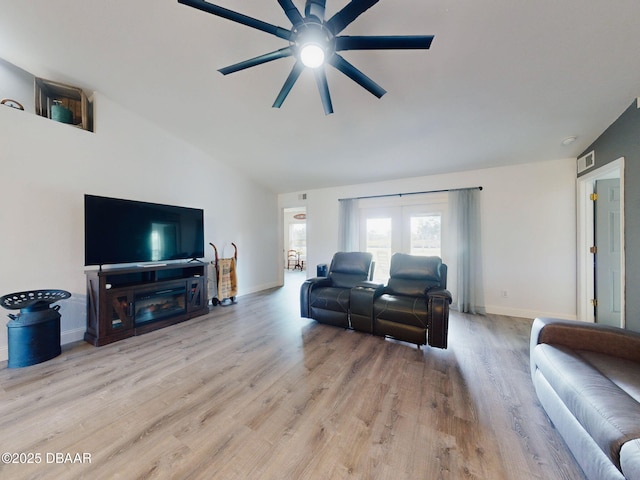 living room featuring light wood-type flooring, ceiling fan, and vaulted ceiling