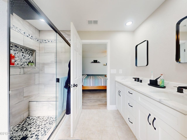 bathroom featuring tile patterned floors, an enclosed shower, and vanity