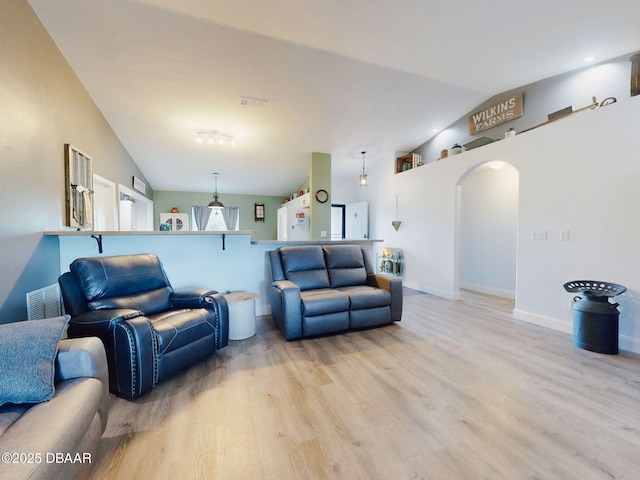 living room featuring light hardwood / wood-style flooring and vaulted ceiling