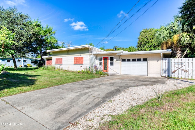 single story home featuring a garage and a front lawn