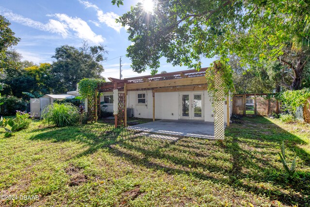 rear view of property with central AC unit, a patio area, a lawn, and french doors