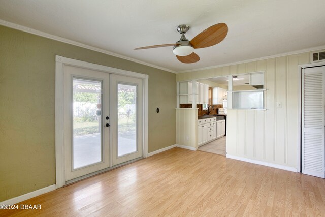 unfurnished living room with ornamental molding, ceiling fan, french doors, and light hardwood / wood-style floors